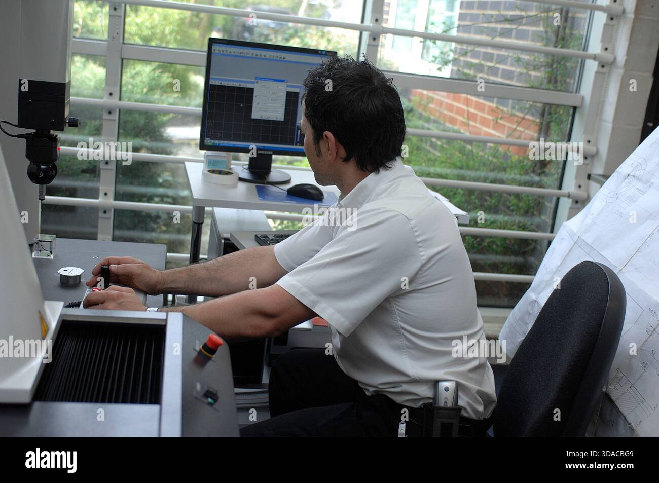Workers guiding a computed guided lathe in an engineering factory. Stock Photo