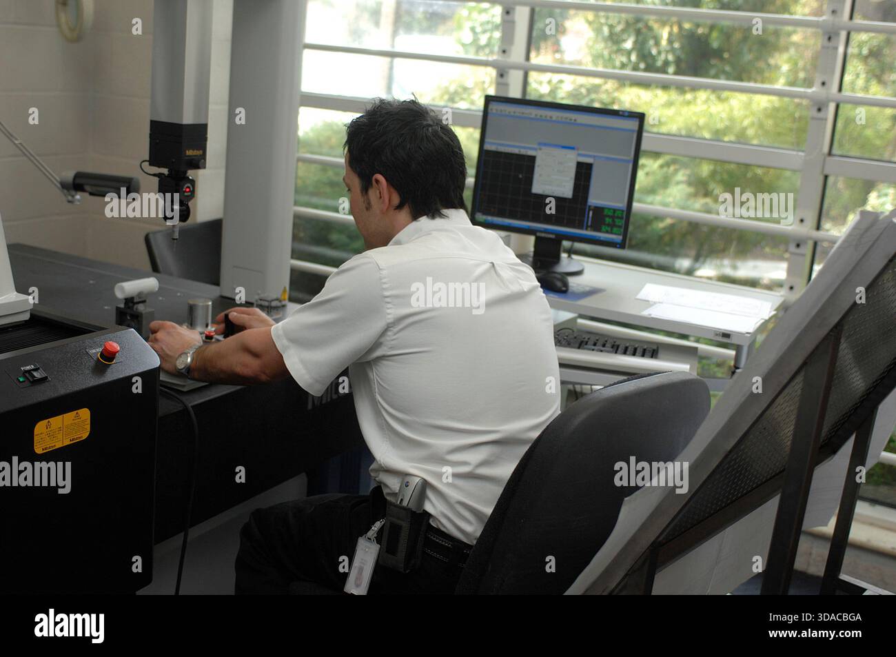 Workers guiding a computed guided lathe in an engineering factory. Stock Photo