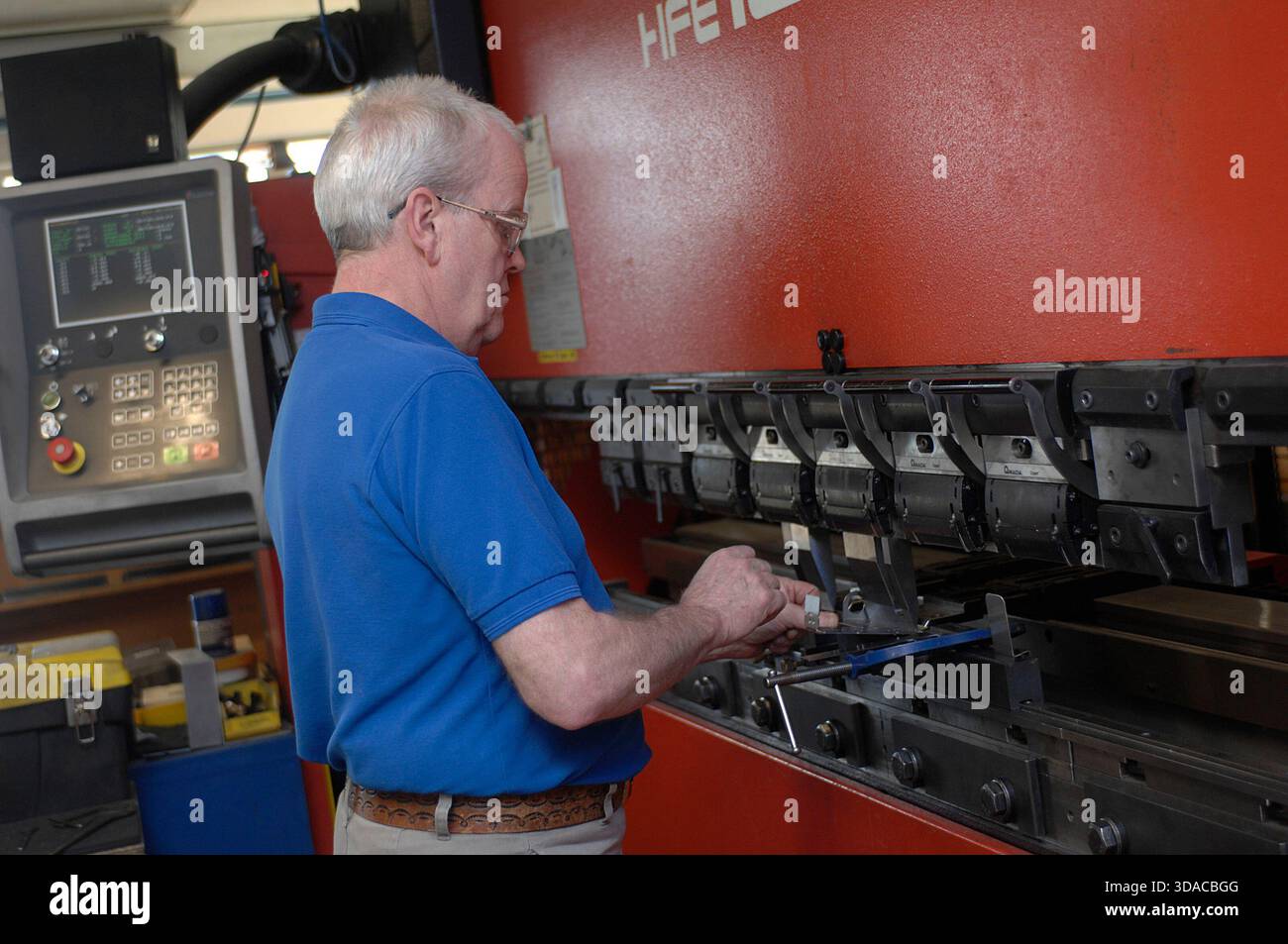 Workers guiding a computed guided lathe in an engineering factory. Stock Photo