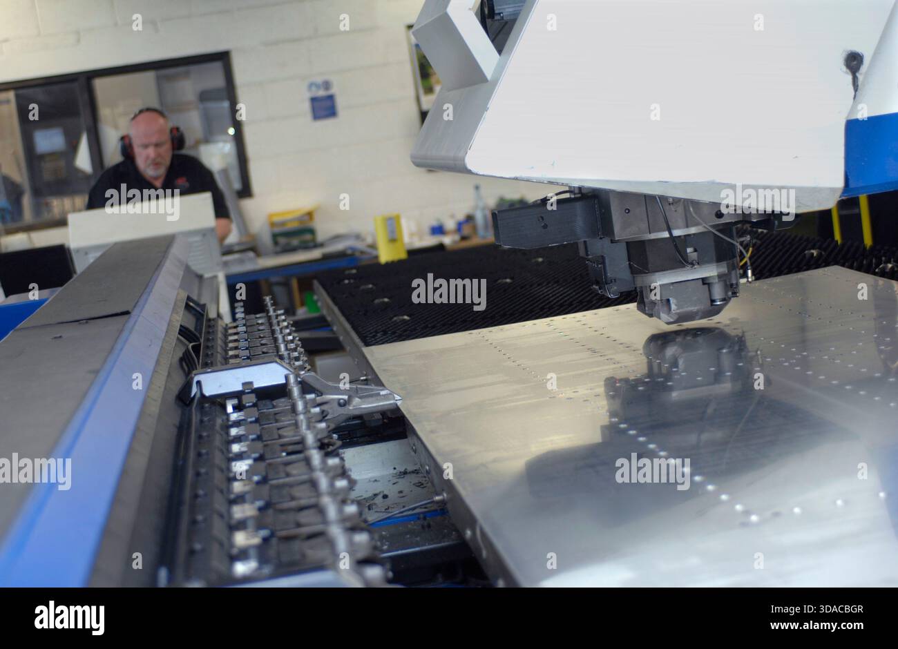 Workers guiding a computed guided lathe in an engineering factory. Stock Photo