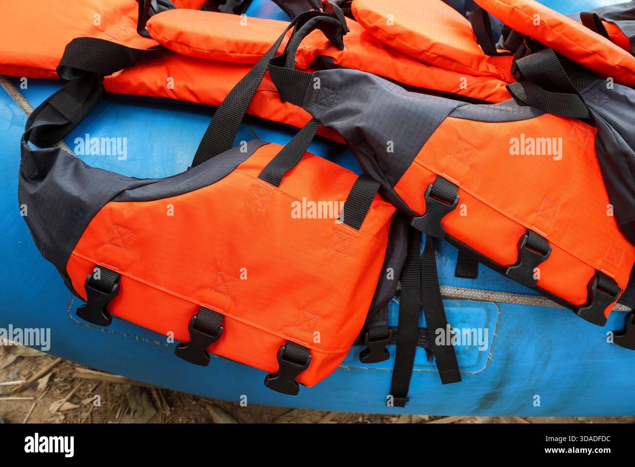 Bright orange life jacket and safety vest equipment ready on blue ...