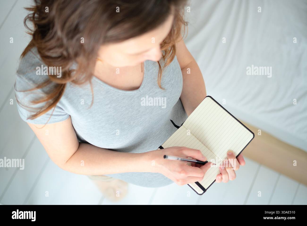 Maternity Writing Top-down view of pregnant female writing important delivery notes in ...