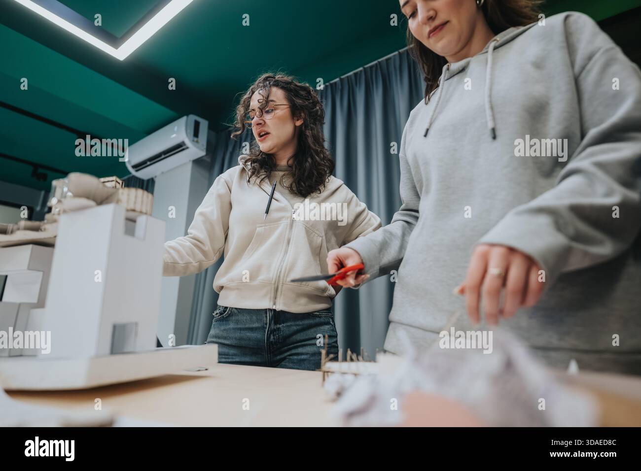 Two students collaborate in a design workshop to build a scale model and prototype Stock Photo