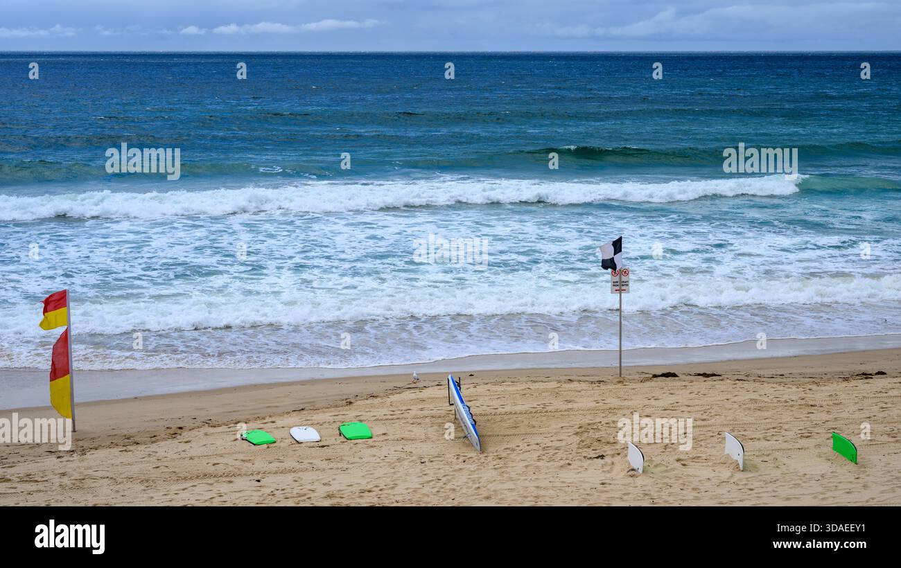 Australian beach with surf boards and warning flags Stock Photo