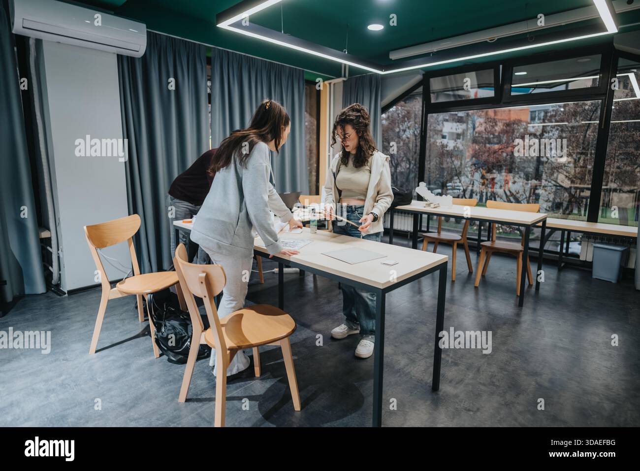 Students collaborate on a project in a modern classroom during a group study session Stock Photo
