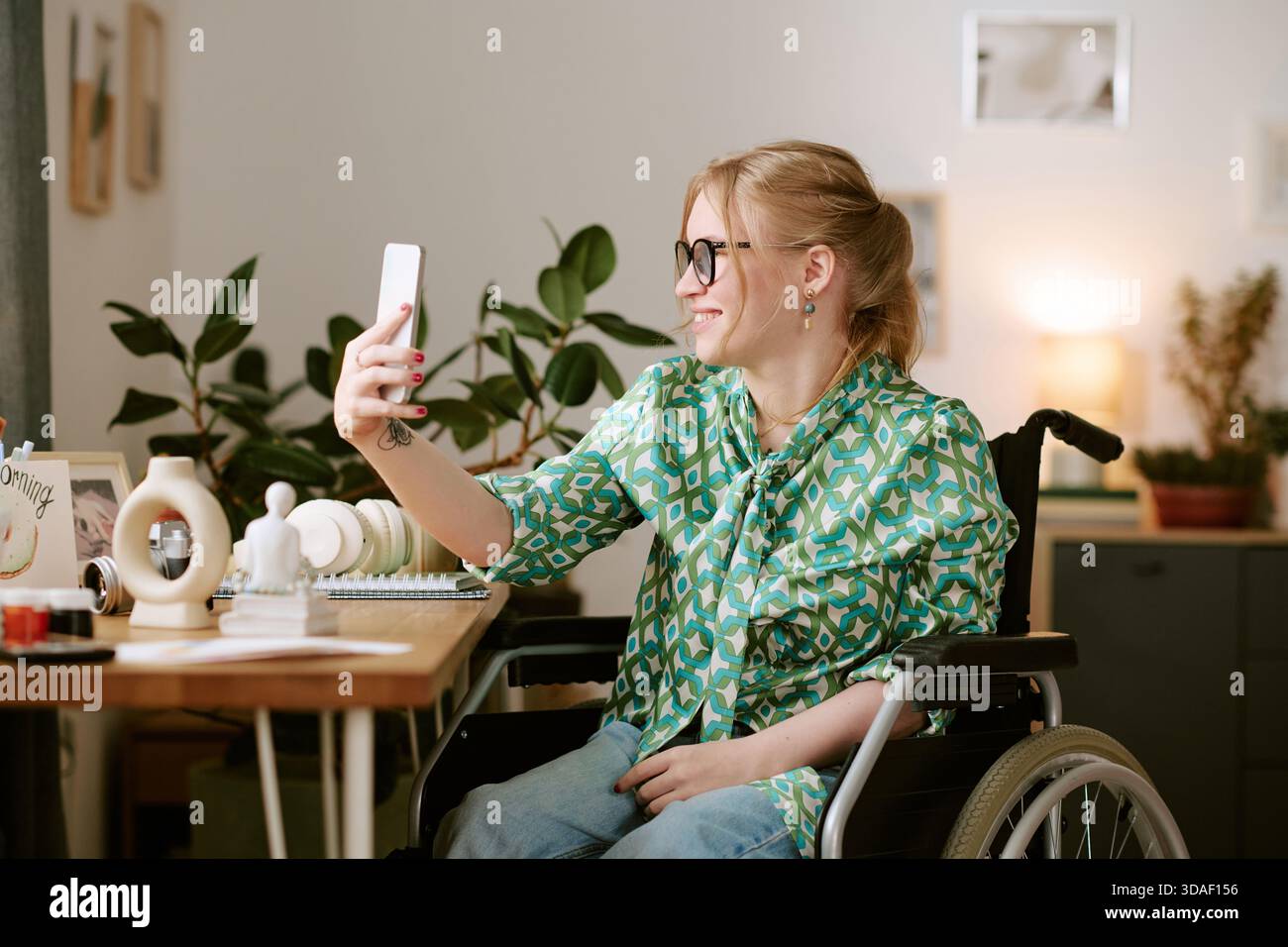 Young Woman with Disability Smiling While Taking Selfie Indoors Stock Photo