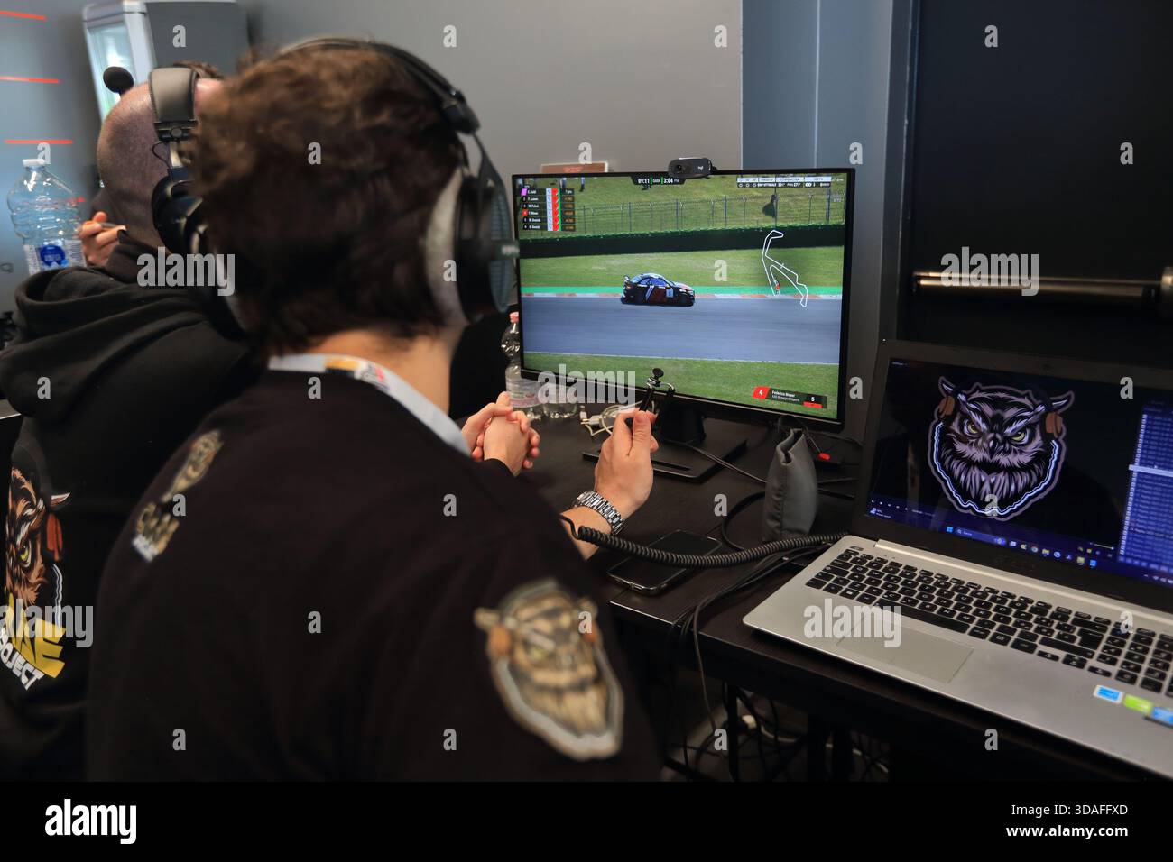 Players participate in a race in the racing car driving simulator at the Misano World Circuit Marco Simoncelli. The race judges. - Stock Image