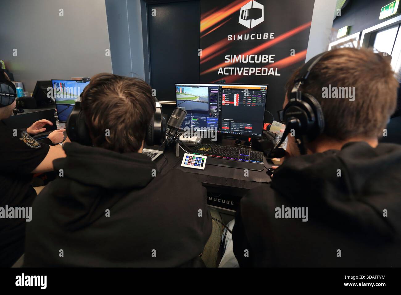 Players participate in a race in the racing car driving simulator at the Misano World Circuit Marco Simoncelli. The race judges. - Stock Image