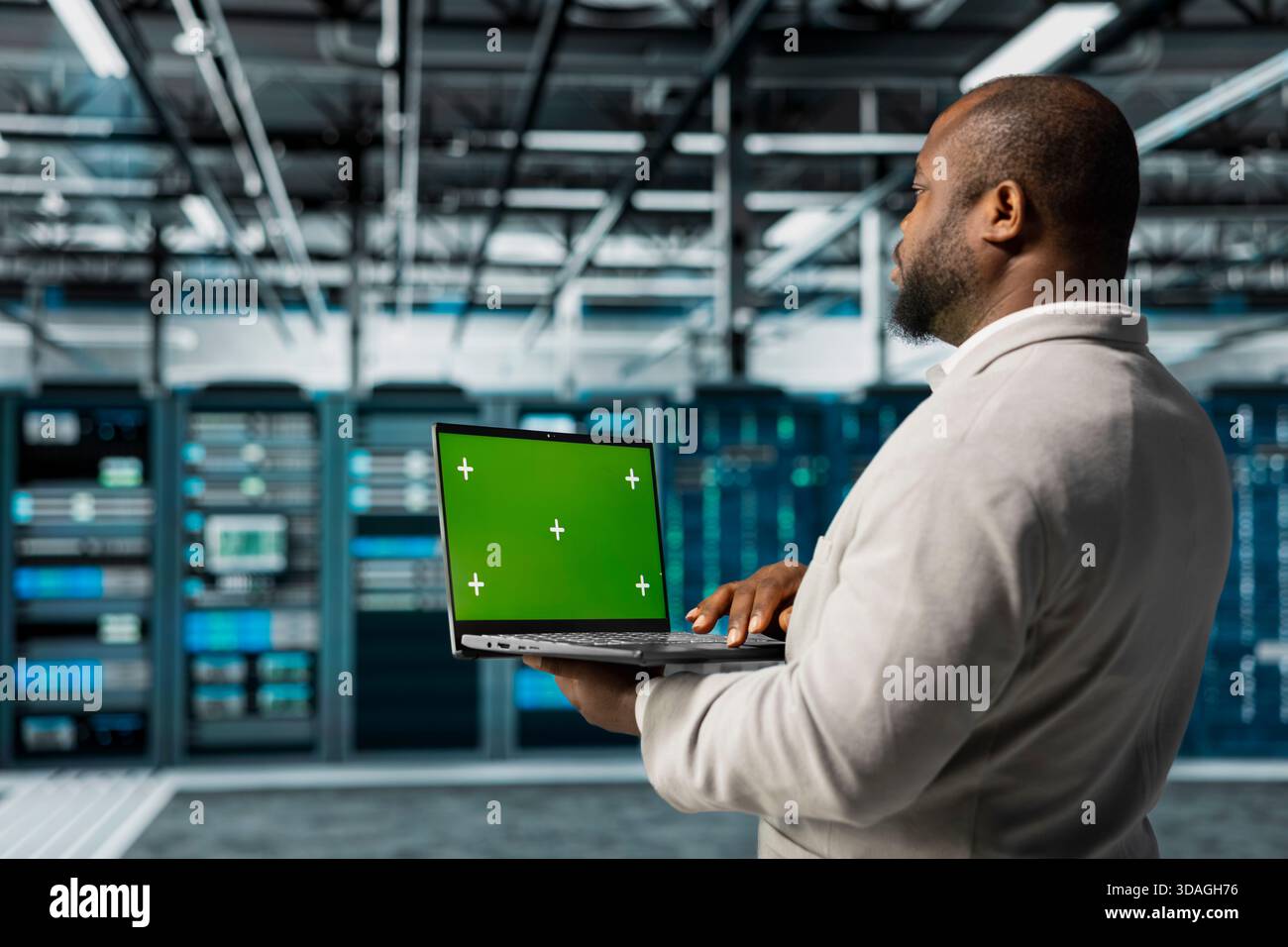 Engineer in server farm using green screen mockup laptop, checking recovery plan. Data center IT expert using chroma key notebook, troubleshooting rigs connectivity issues Stock Photo