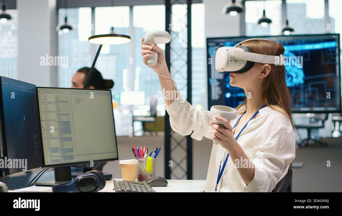 Junior dev using virtual reality at work, testing generative AI machine learning algorithms. Young woman wearing VR goggles equipment scaling productivity with AI large language model code, camera A Stock Photo