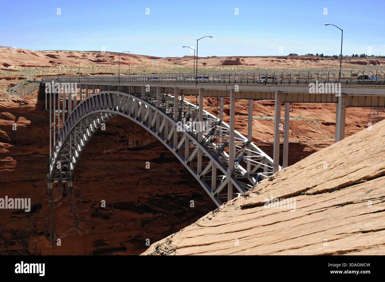 Steel bridge in a dry desert landscape with reddish rocks and arched ...