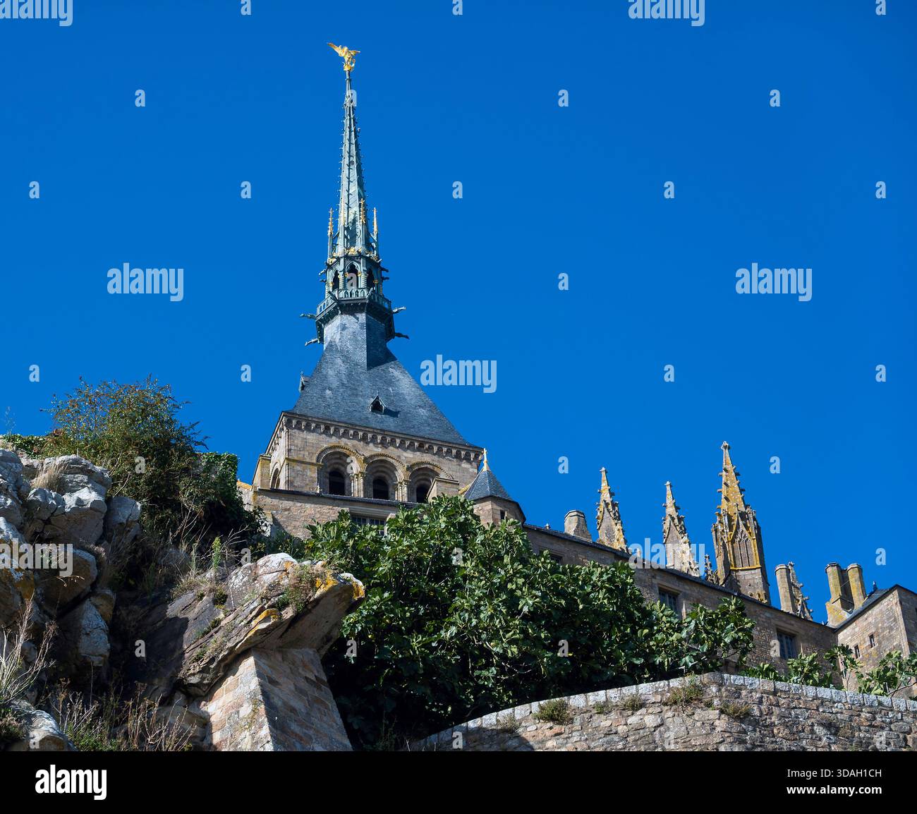 Spire with St Michael defeating a dragon on top of the abbey at Mont ...