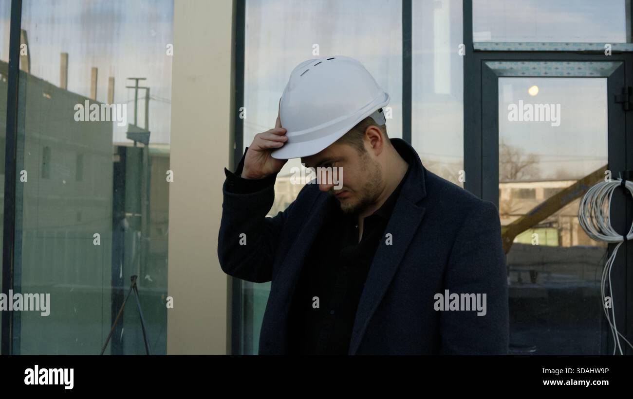 Focused architect engineer examines the building structure outdoors Stock Photo