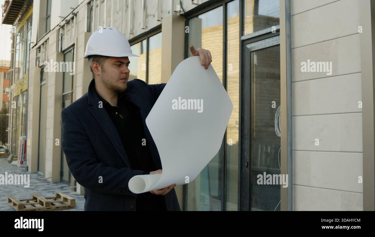Two engineers or architects discussing plans on a construction site outdoors Stock Photo