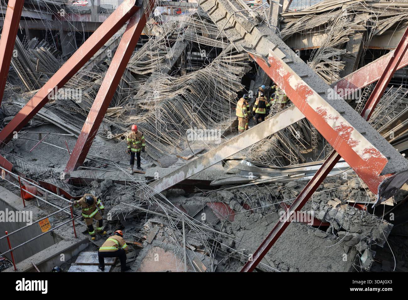 Firefighters try to rescue workers trapped under a collapsed structure ...