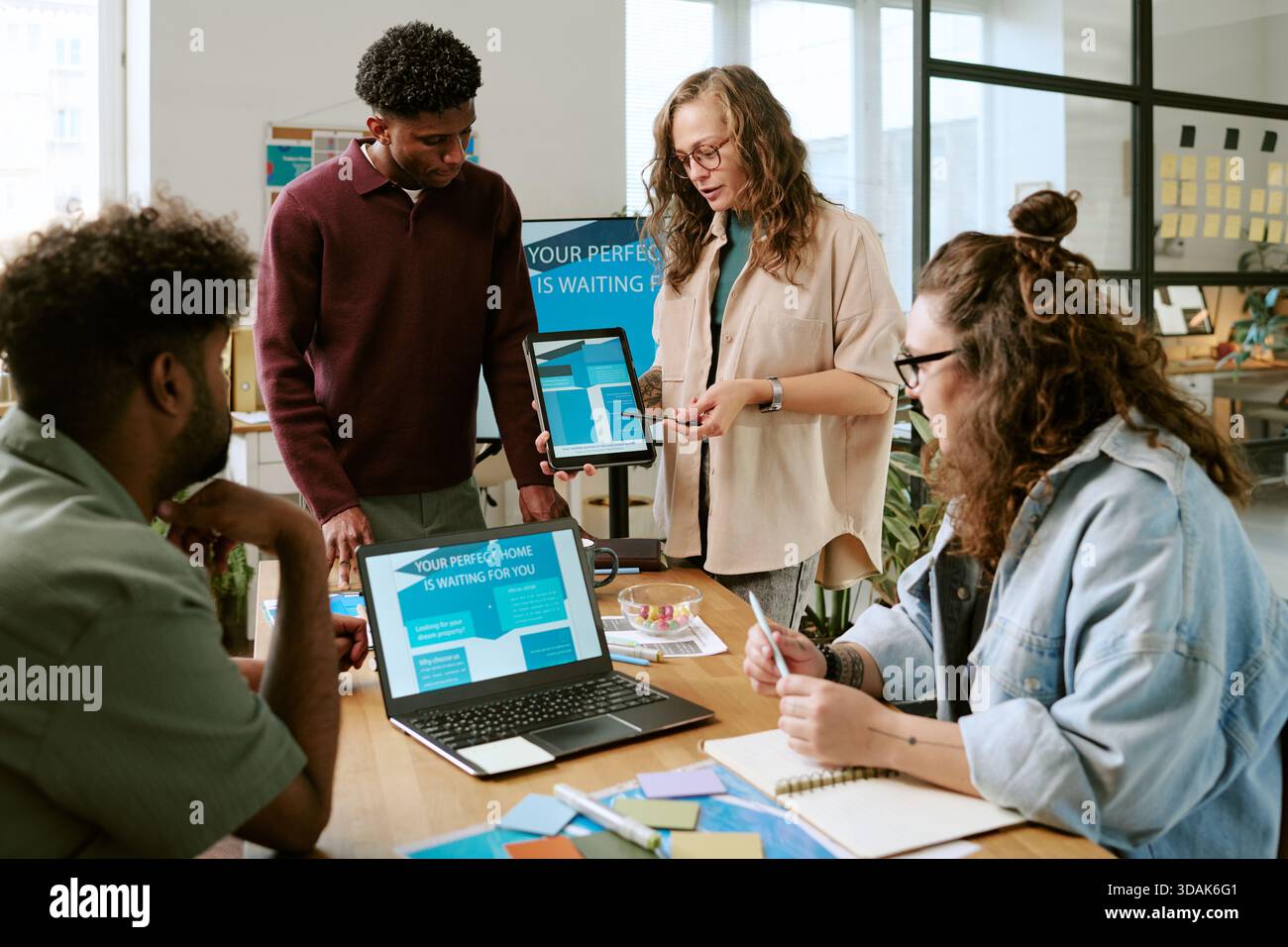 Diverse Young Adults Collaborating during Creative Office Meeting Stock Photo