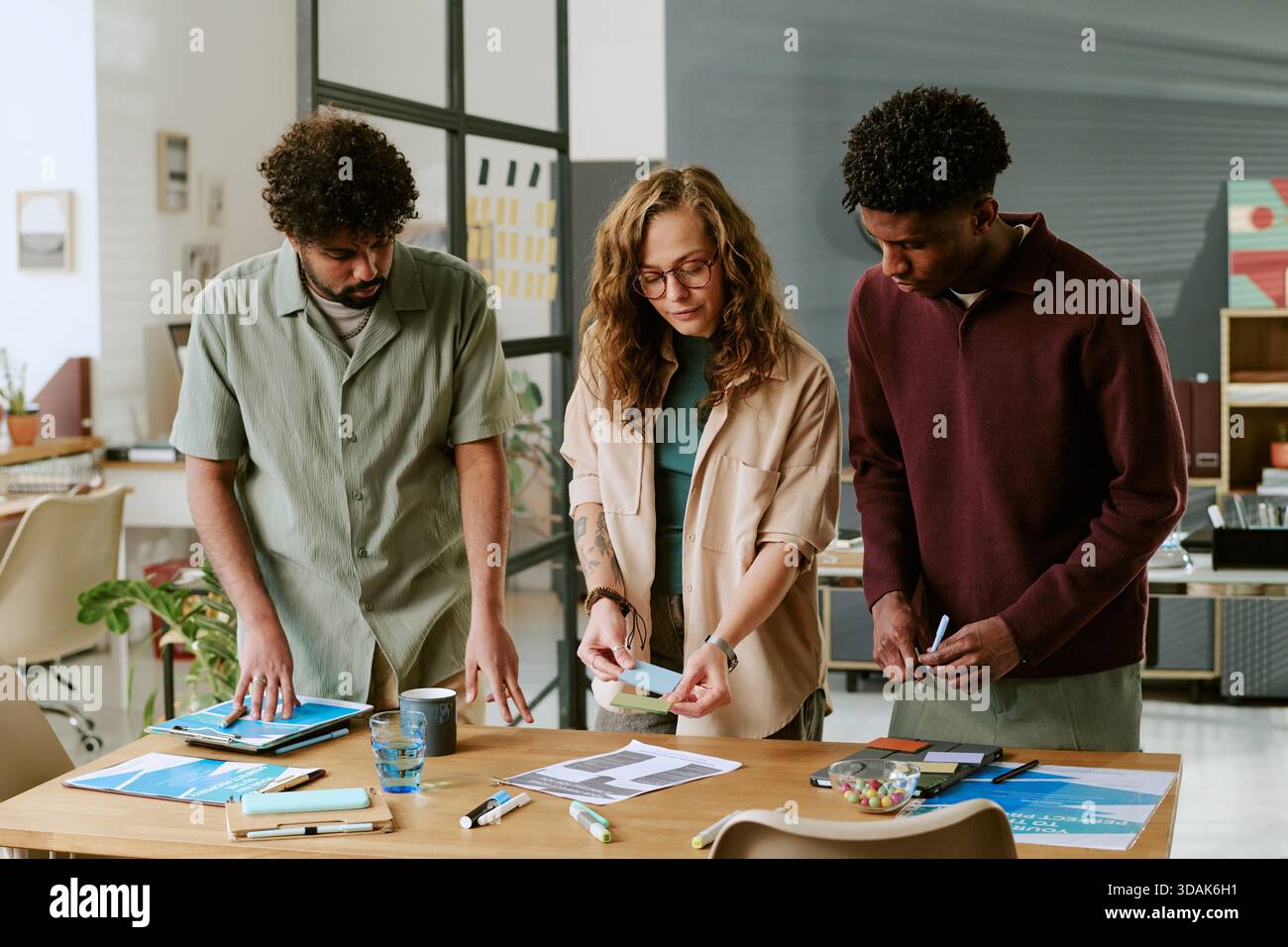 Young Multiethnic Colleagues Collaborating on Project in Modern Office Setting Stock Photo