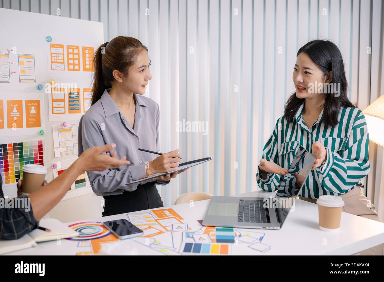 UX/UI designers collaborating during a creative workshop to test interface ideas and exchange feedback for app development, emphasizing teamwork and i Stock Photo