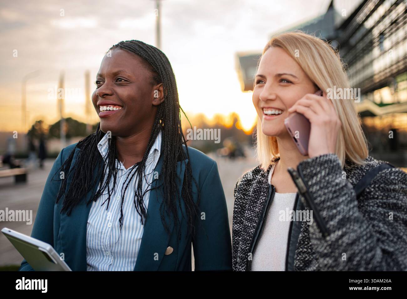 Diverse businesswomen smiling walking using technology collaborating Stock Photo