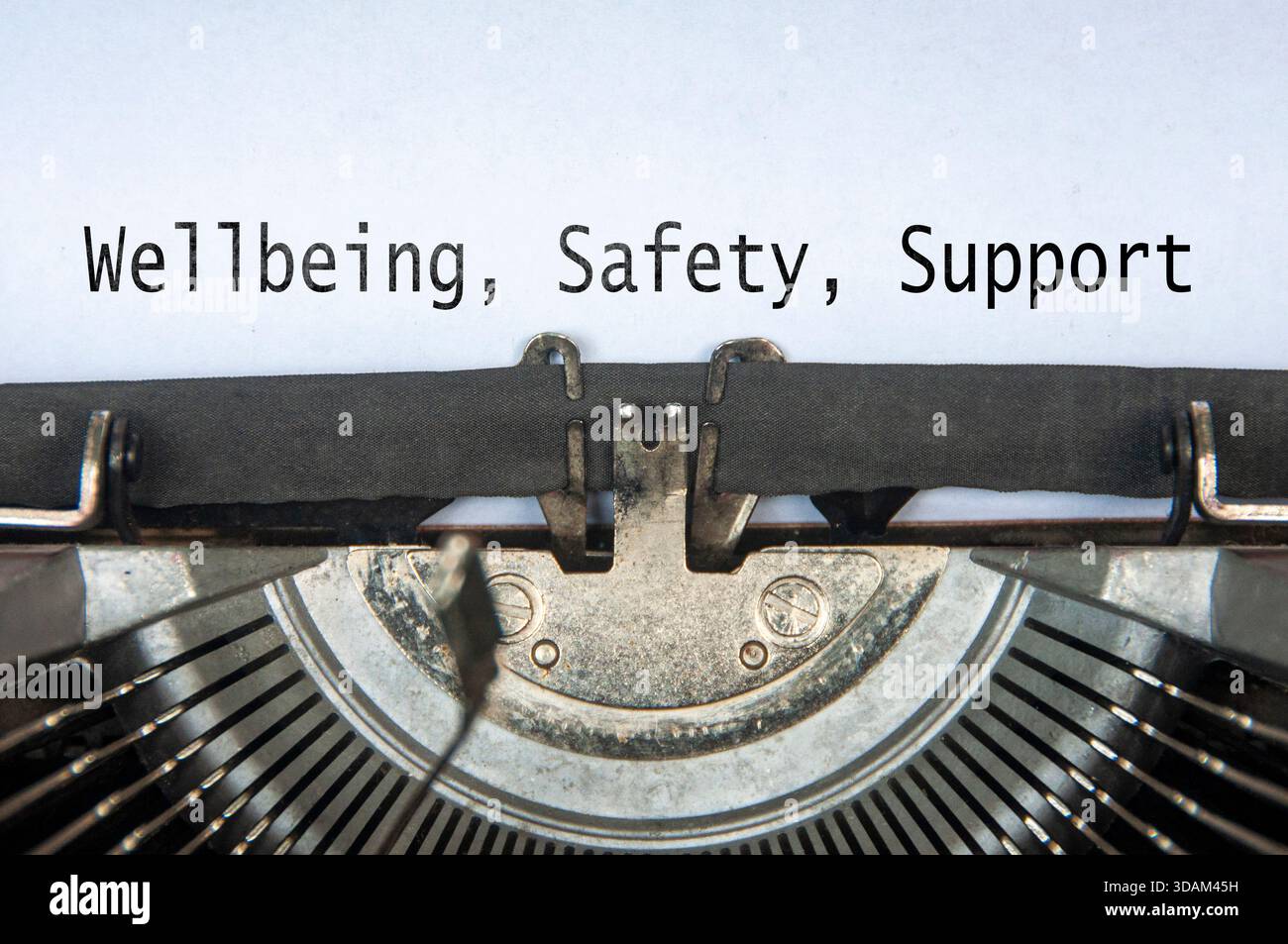 Wellbeing, Safety and Support text on old typewriter. Stock Photo