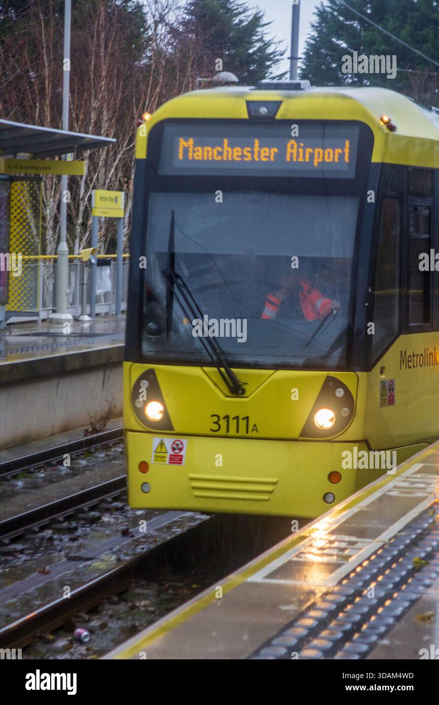 2 December 2025 A public tram on the Manchester Airport route headed to the airport and arriving Northern Moor in Greater Manchester England on a cold Stock Photo