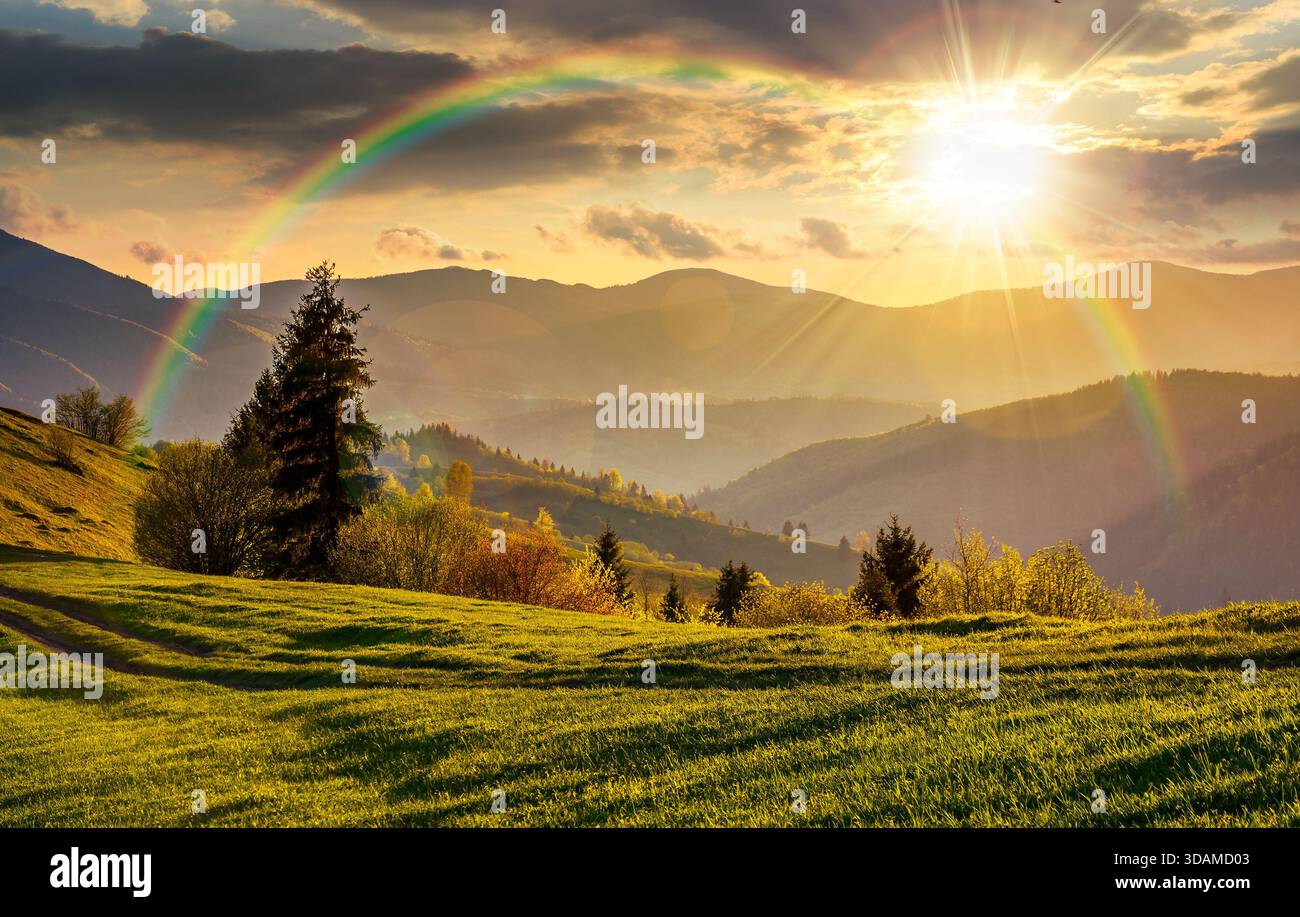 beautiful countryside landscape in springtime at sunset. green grassy slopes of mountainous rural area in evening light. hills rolling in to the dista Stock Photo