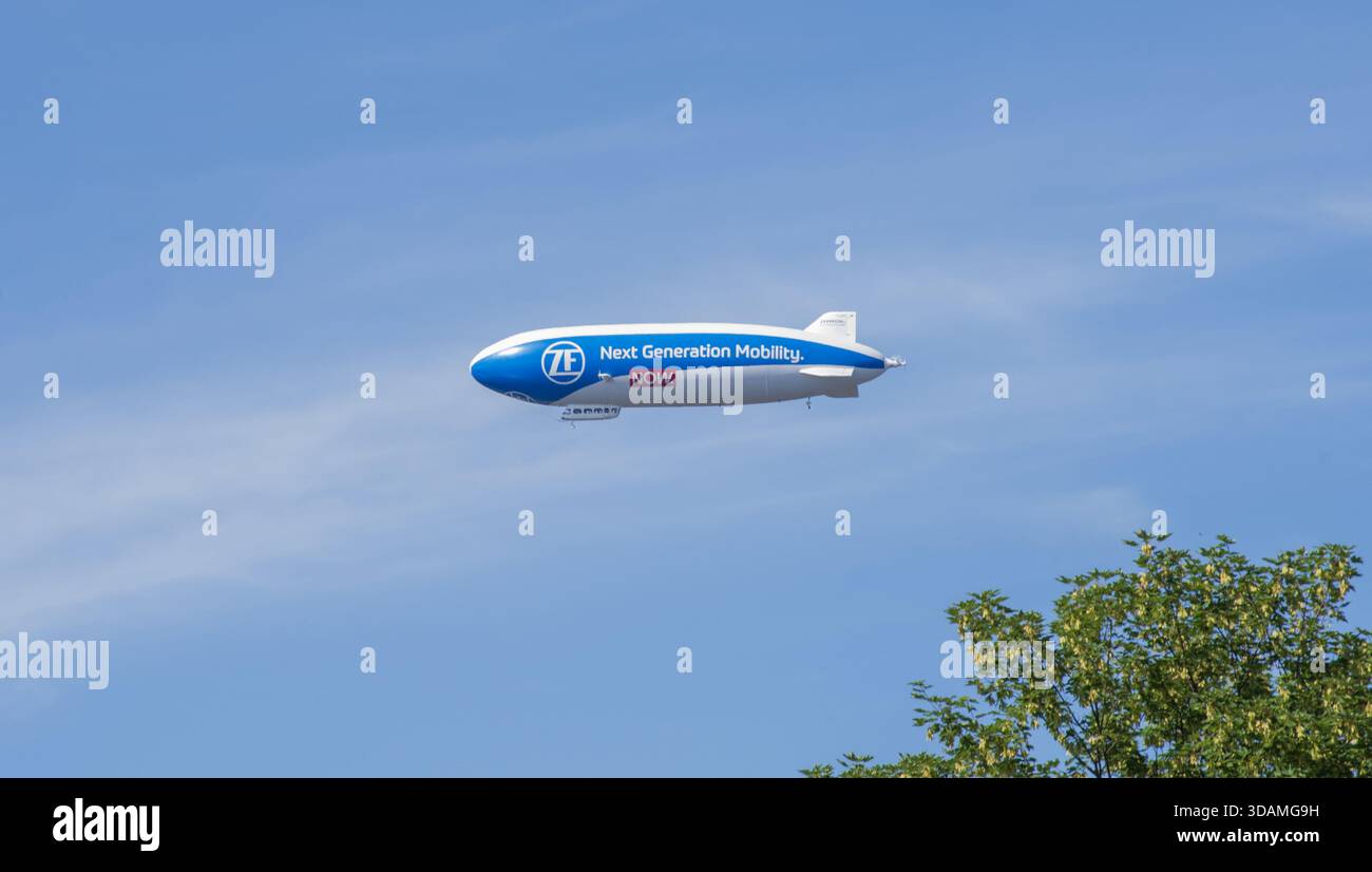 Modern ZF Zeppelin flying in clear blue sky, showing sleek shape and ...