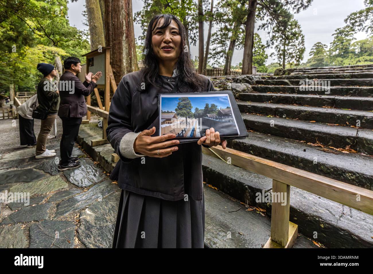 Guide Chifumi Takahashi shows a photograph comparing the current shrine building with its predecessor, Naikū of Ise-jingū, Ise, Mie Prefecture, Japan. Every 20 years, during the Shikinen Sengu ritual, the entire shrine is rebuilt in the traditional style on an adjacent site. Stock Photo