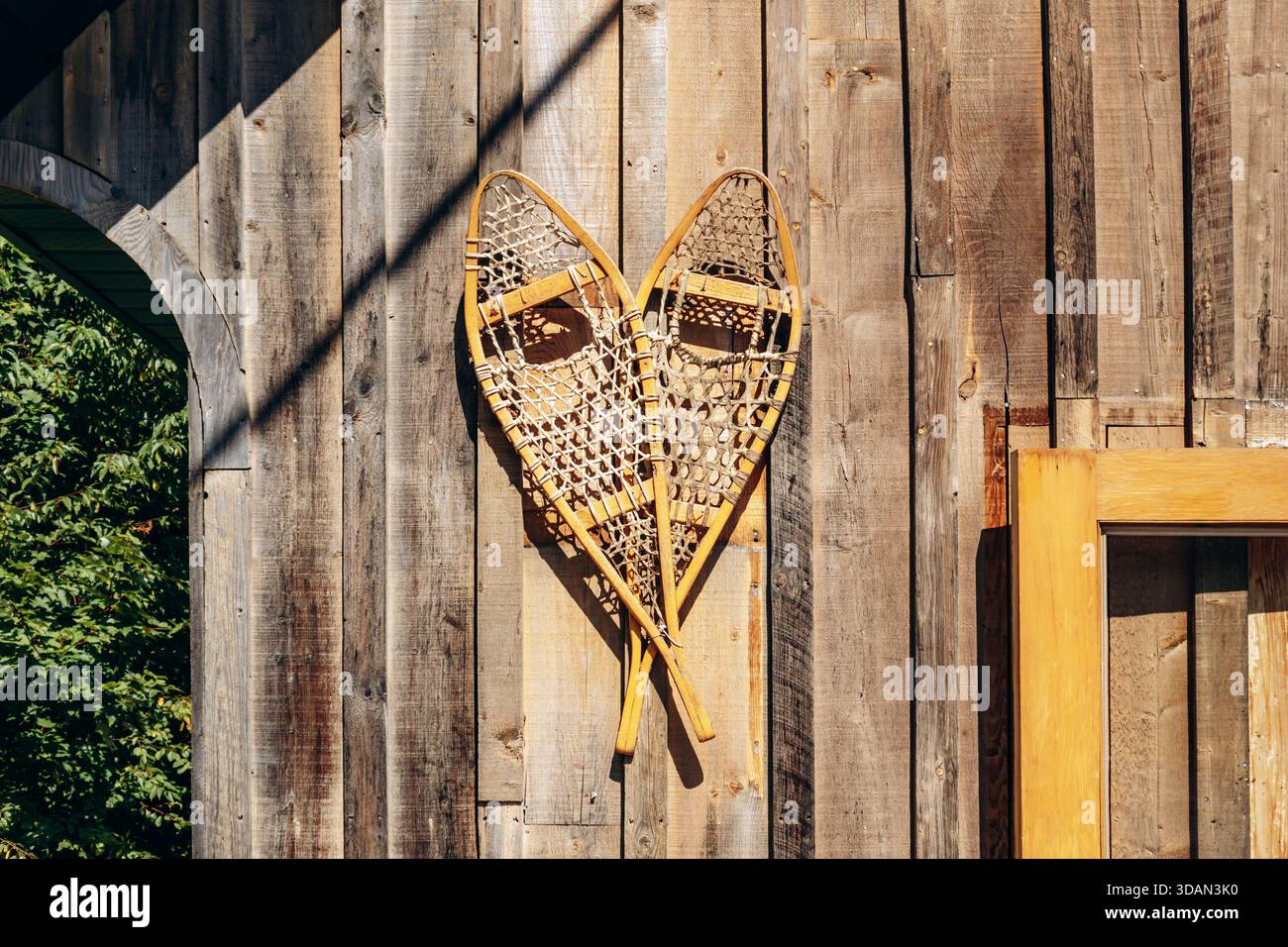 Traditional wooden snowshoes displayed on the exterior wall of a rustic ...