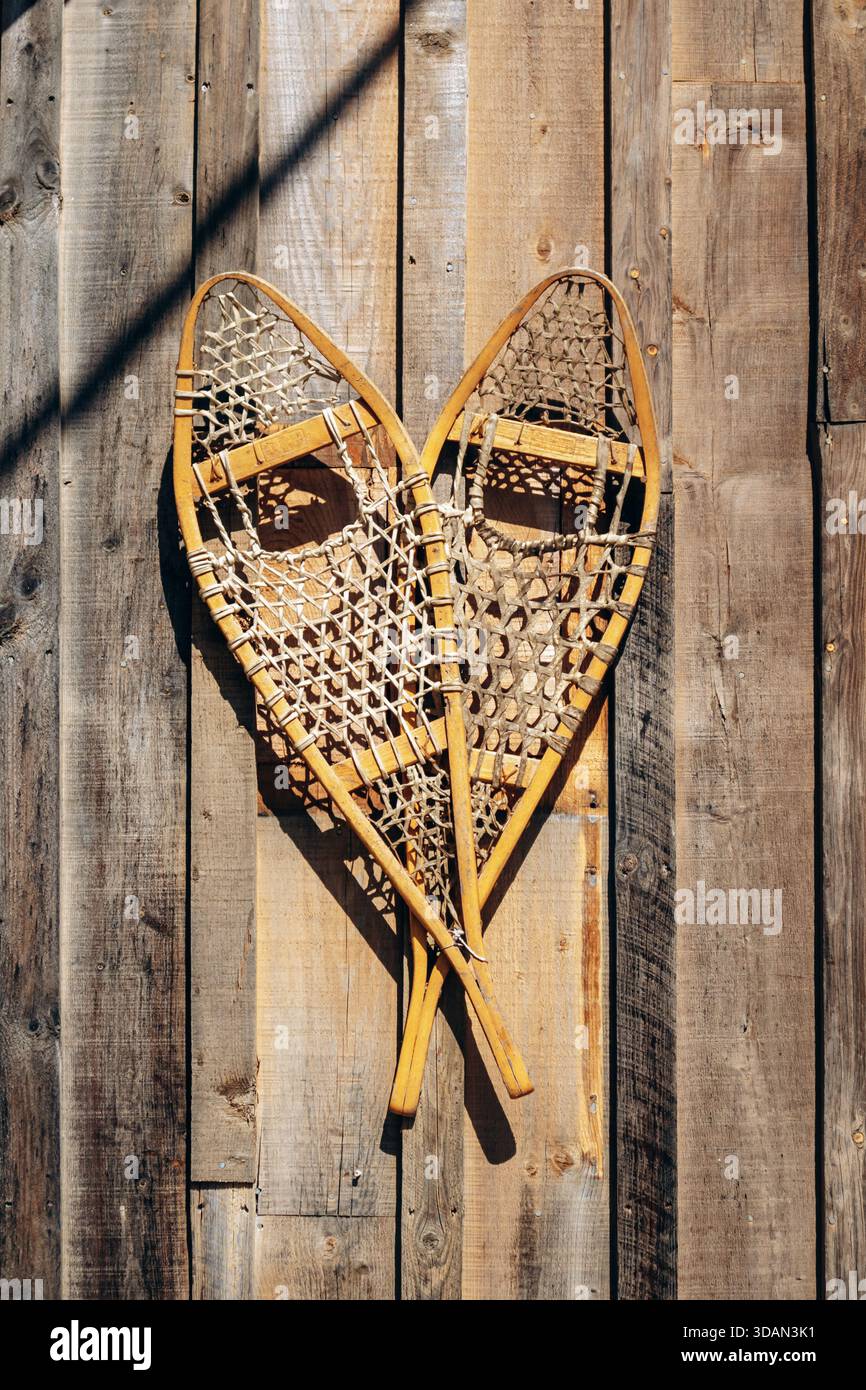 Traditional wooden snowshoes displayed on the exterior wall of a rustic ...