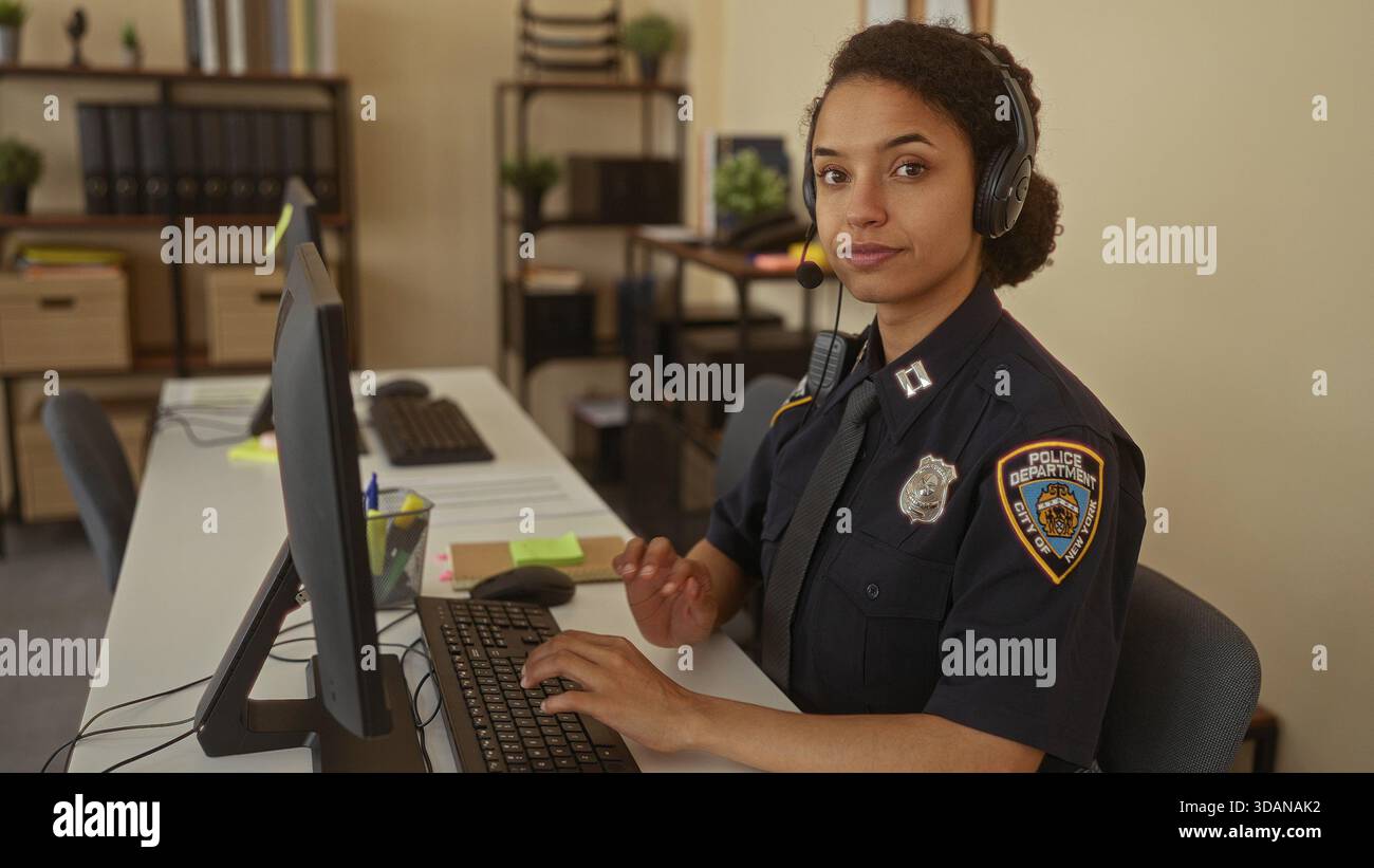 Young hispanic policewoman in uniform typing on computer keyboard at ...
