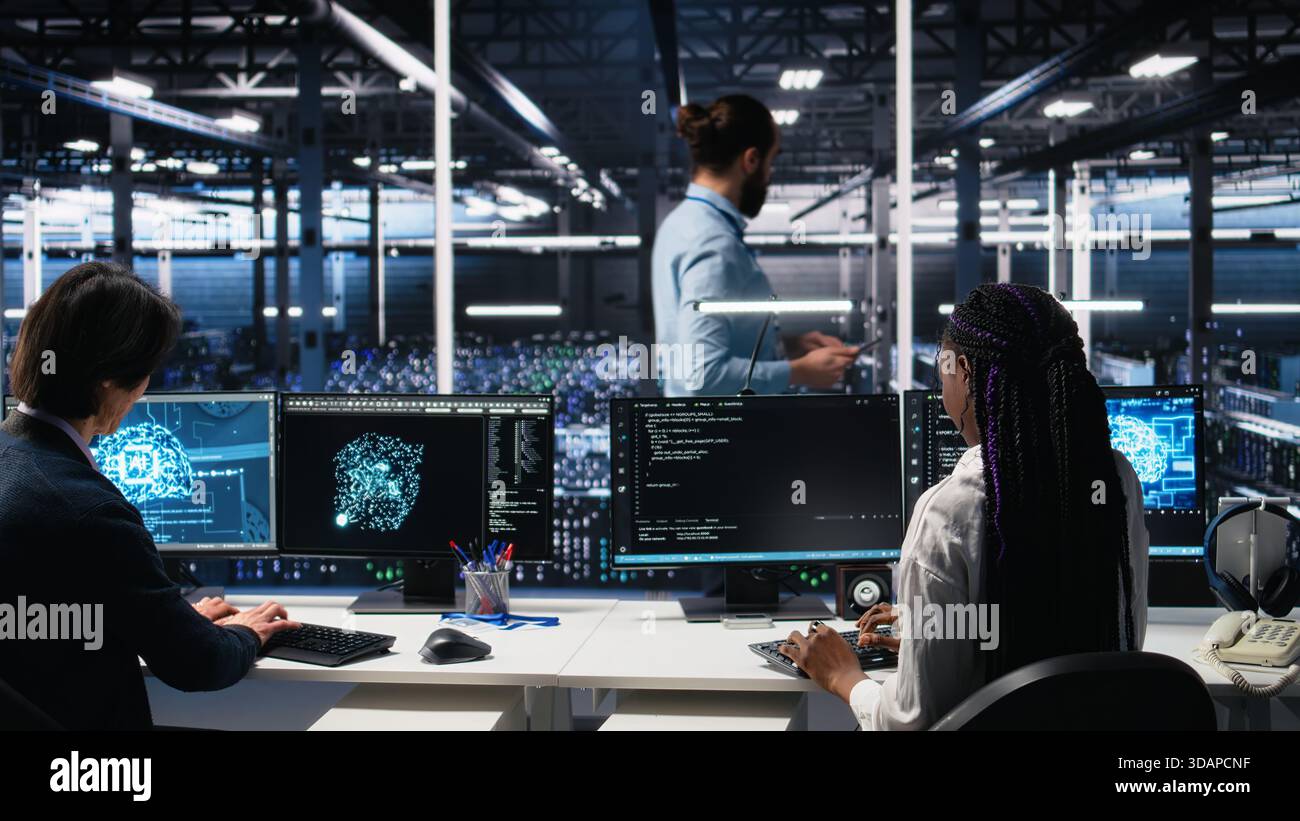 Data center manager checking work done by admins using deep learning to analyze datasets. Server hub supervisor overseeing IT specialists using AI neural networks to recognize data patterns, camera A Stock Photo