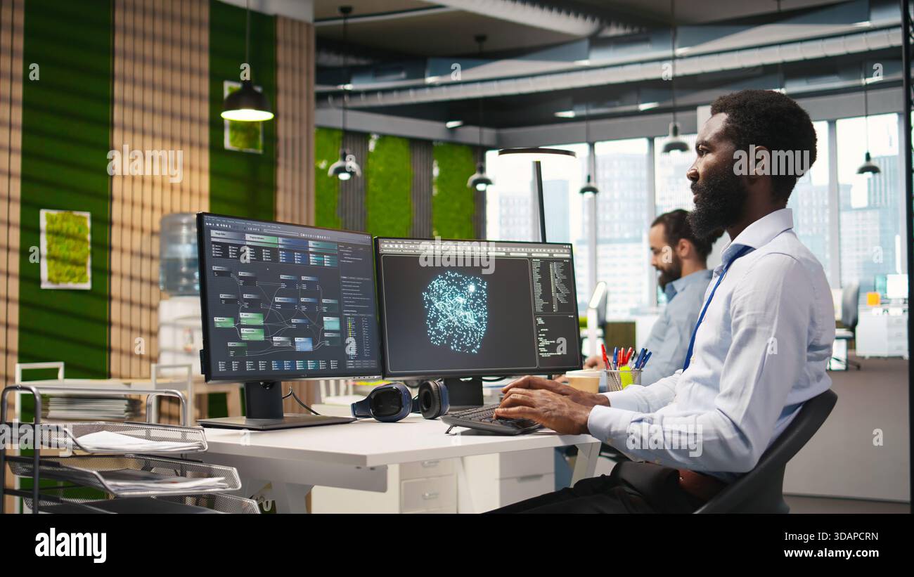 Programmer optimizing performance using AI LLM chatbot recommendations. African american worker uses artificial intelligence assistant to convert manual workflows into automated scripts, camera A Stock Photo