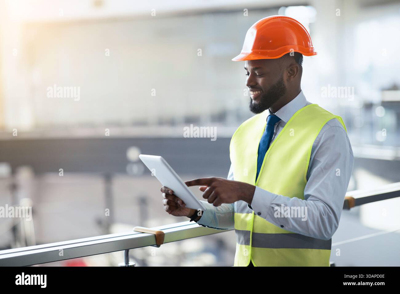 Construction Worker Using Tablet in Industrial Setting During Daytime Stock Photo
