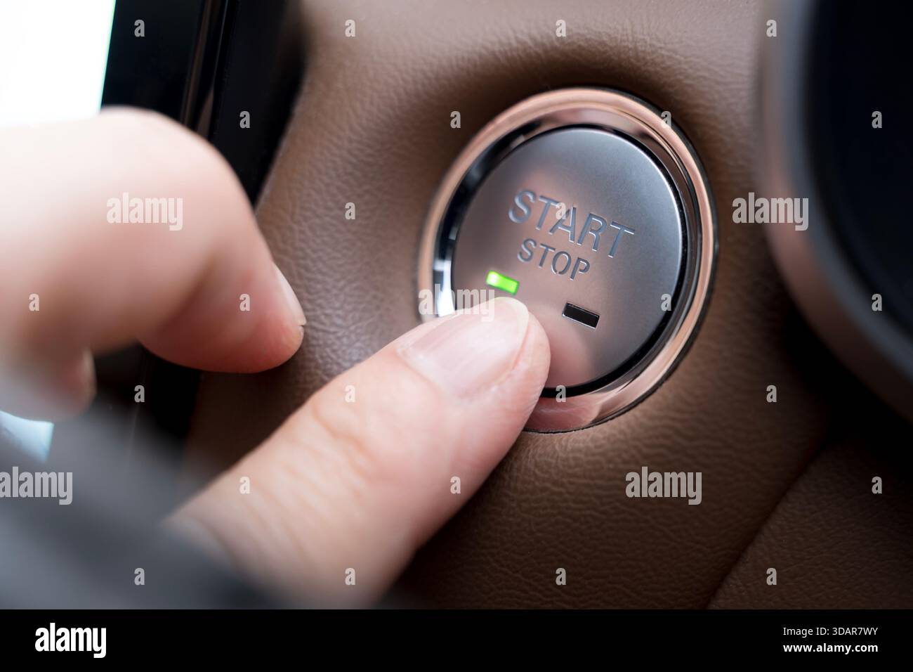 Close-up of a finger pressing a car engine start-stop button, symbolizing modern automotive technology, convenience, smart vehicle systems, innovation Stock Photo