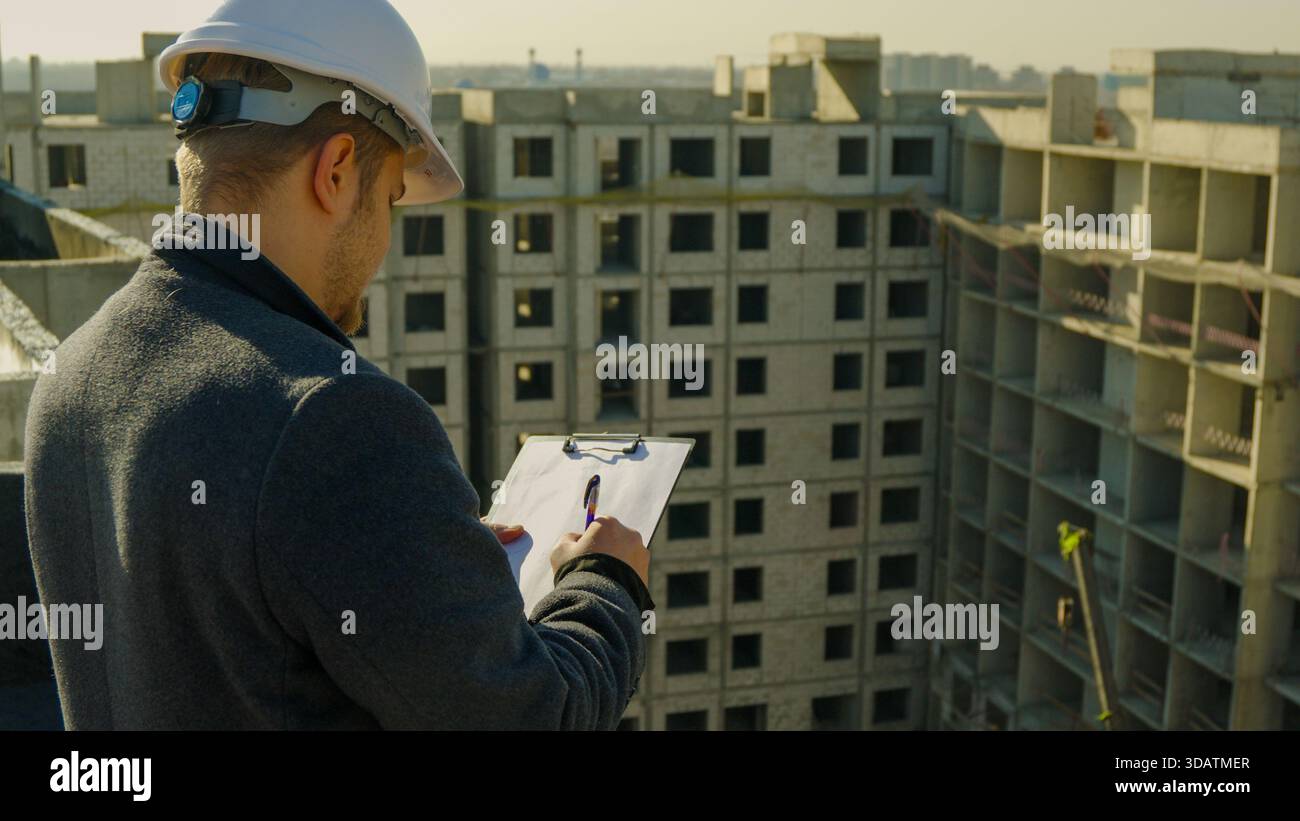 Construction worker or engineer on site checking the building plans on tablet Stock Photo
