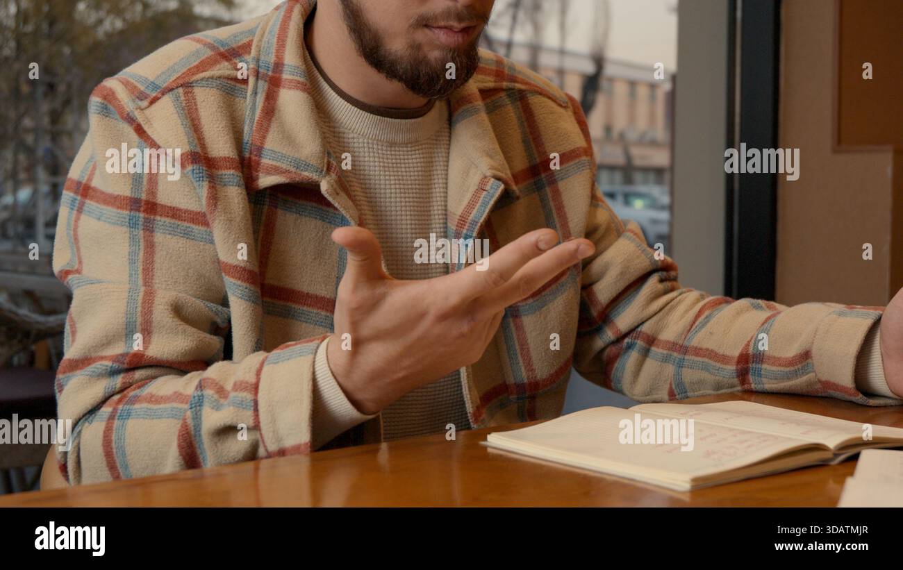 Close-up of two people discussing notes and documents on a cafe table Stock Photo