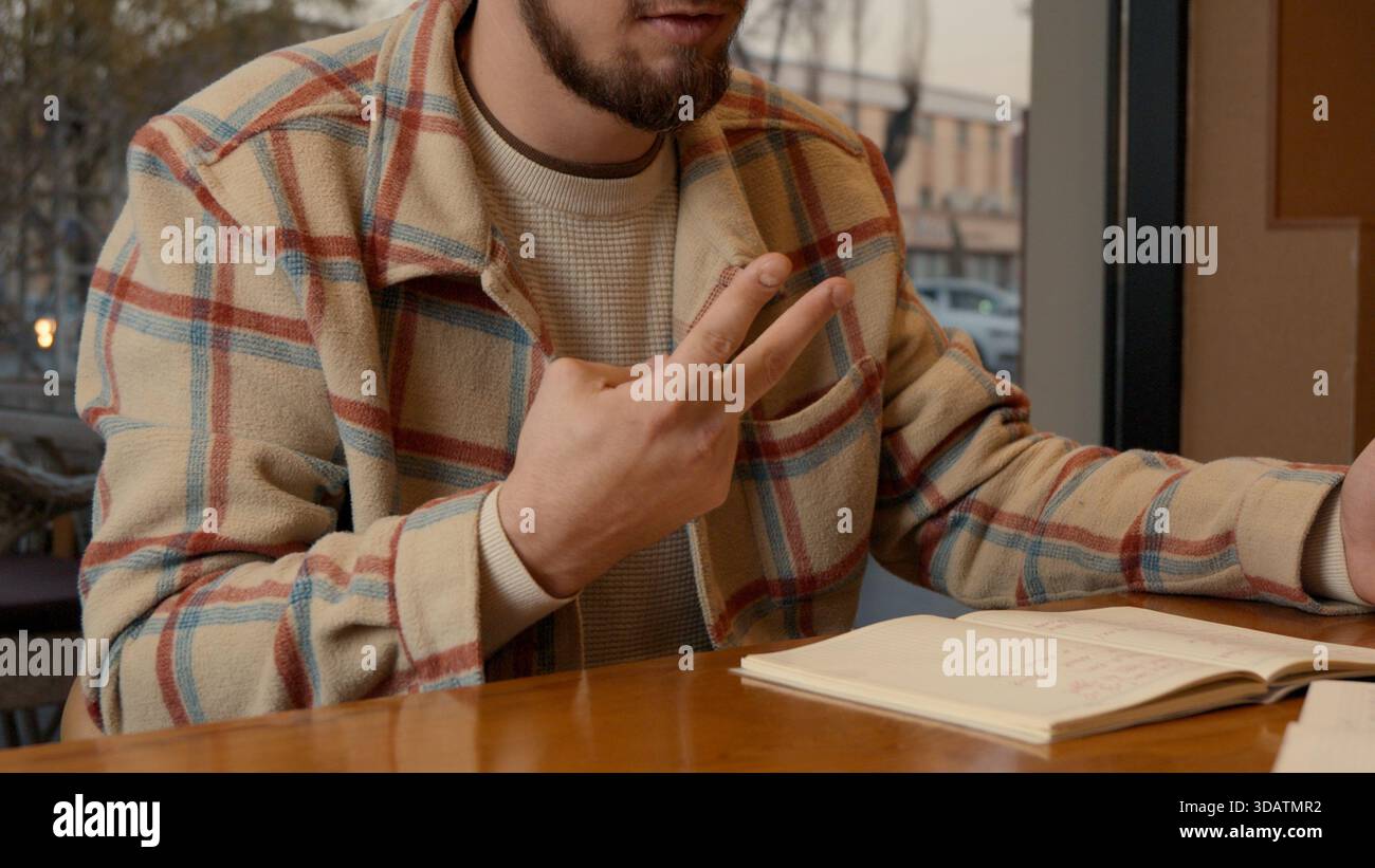 Close-up of two people discussing notes and documents on a cafe table Stock Photo