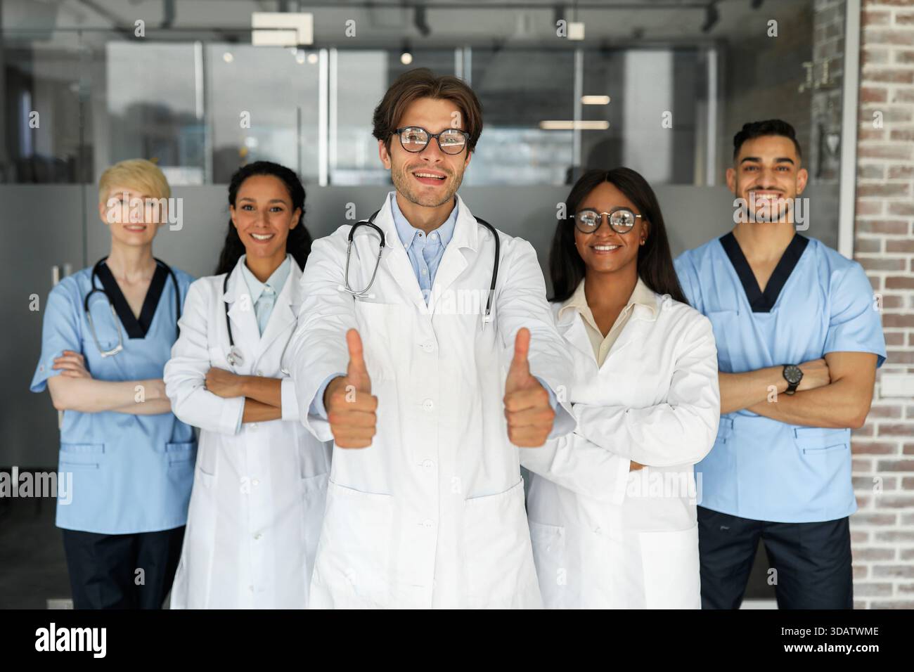 Multiethnic team of doctors posing together, smiling at camera Stock Photo