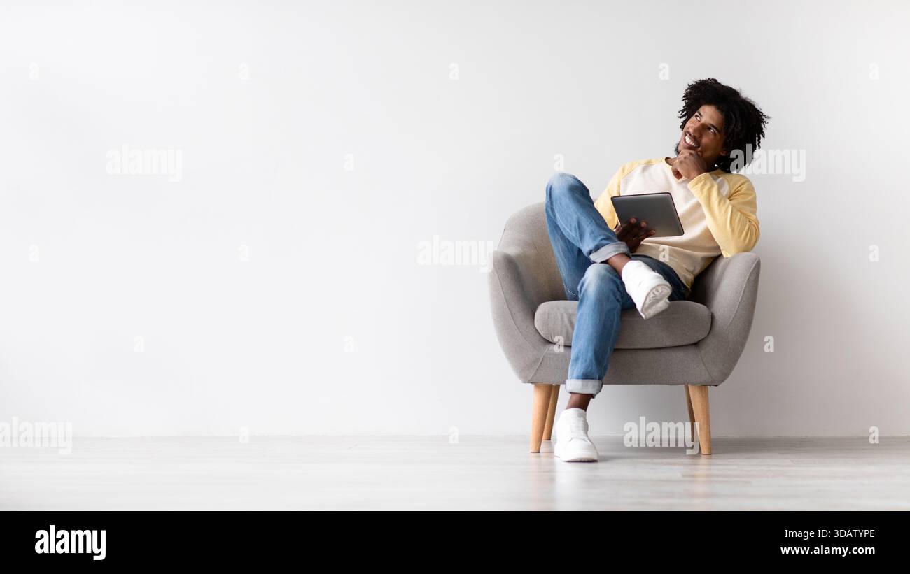 Thoughtful African American Man Considering Options While Using Digital Tablet in Modern Setting Stock Photo