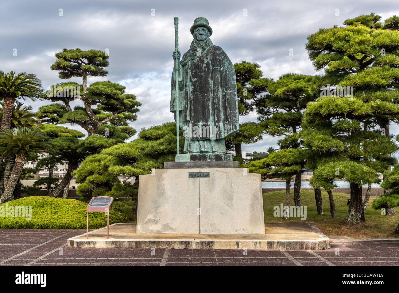 The Kokichi Mikimoto monument, erected in 1953, depicts the ‘Pearl King’ in his later years wearing his imperial decoration. He is wearing a Yamataka hat and a cloak. Toba, Mie, Japan Stock Photo