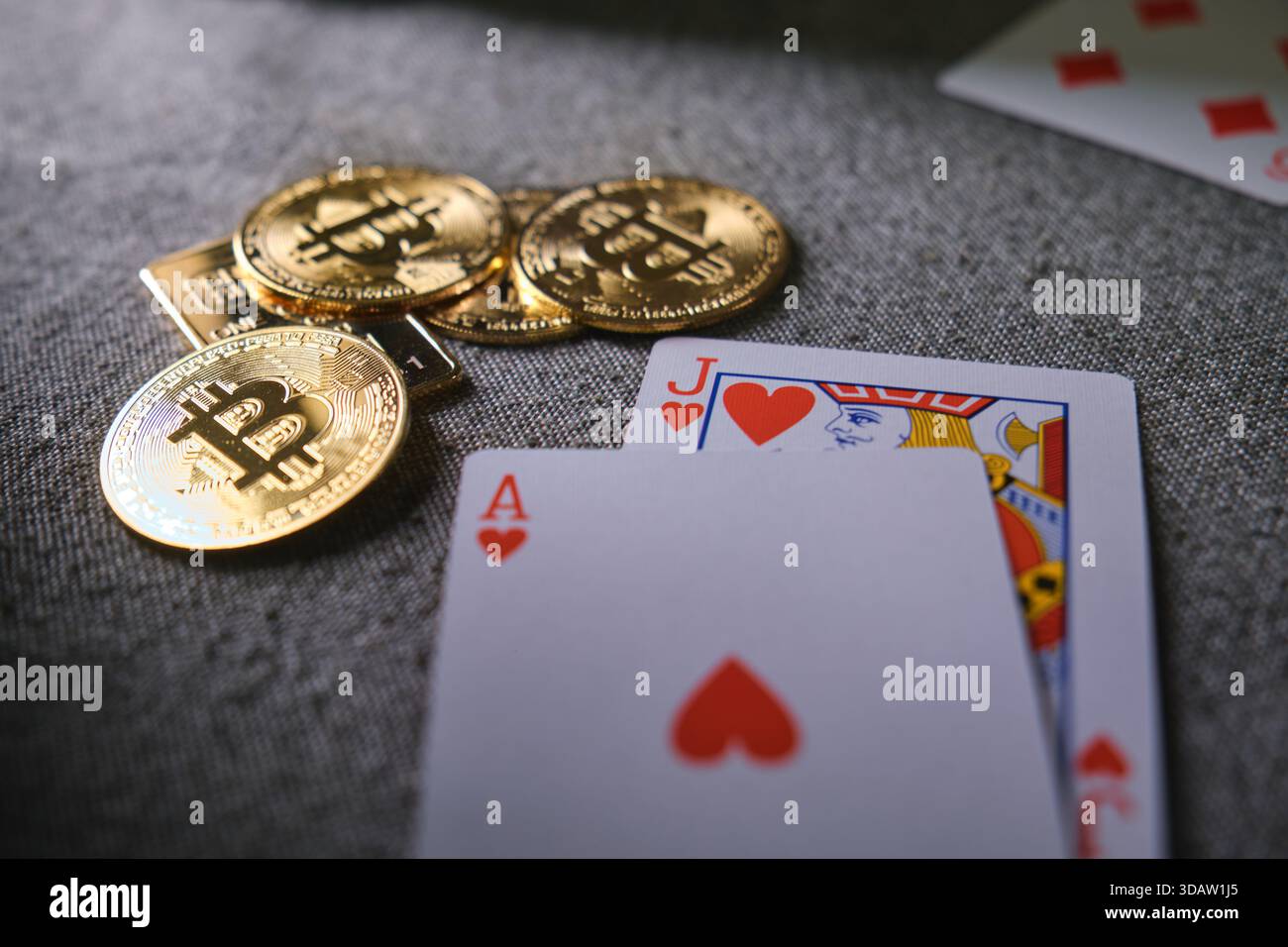 Bitcoin cryptocurrency coins and casino playing cards on a gray fabric surface Stock Photo