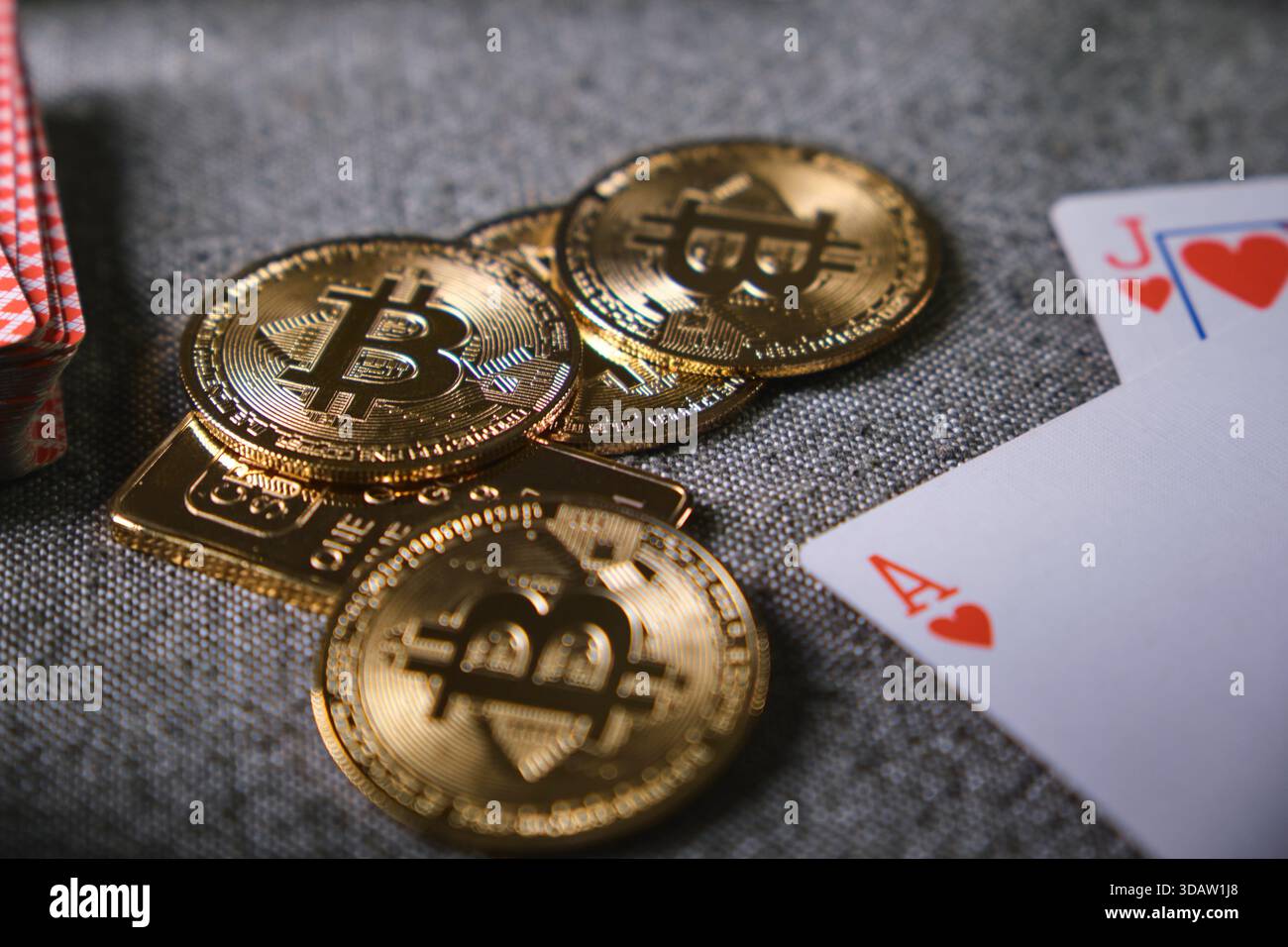 Bitcoin physical coins, gold bar, and playing cards representing cryptocurrency  gambling risks Stock Photo - Alamy