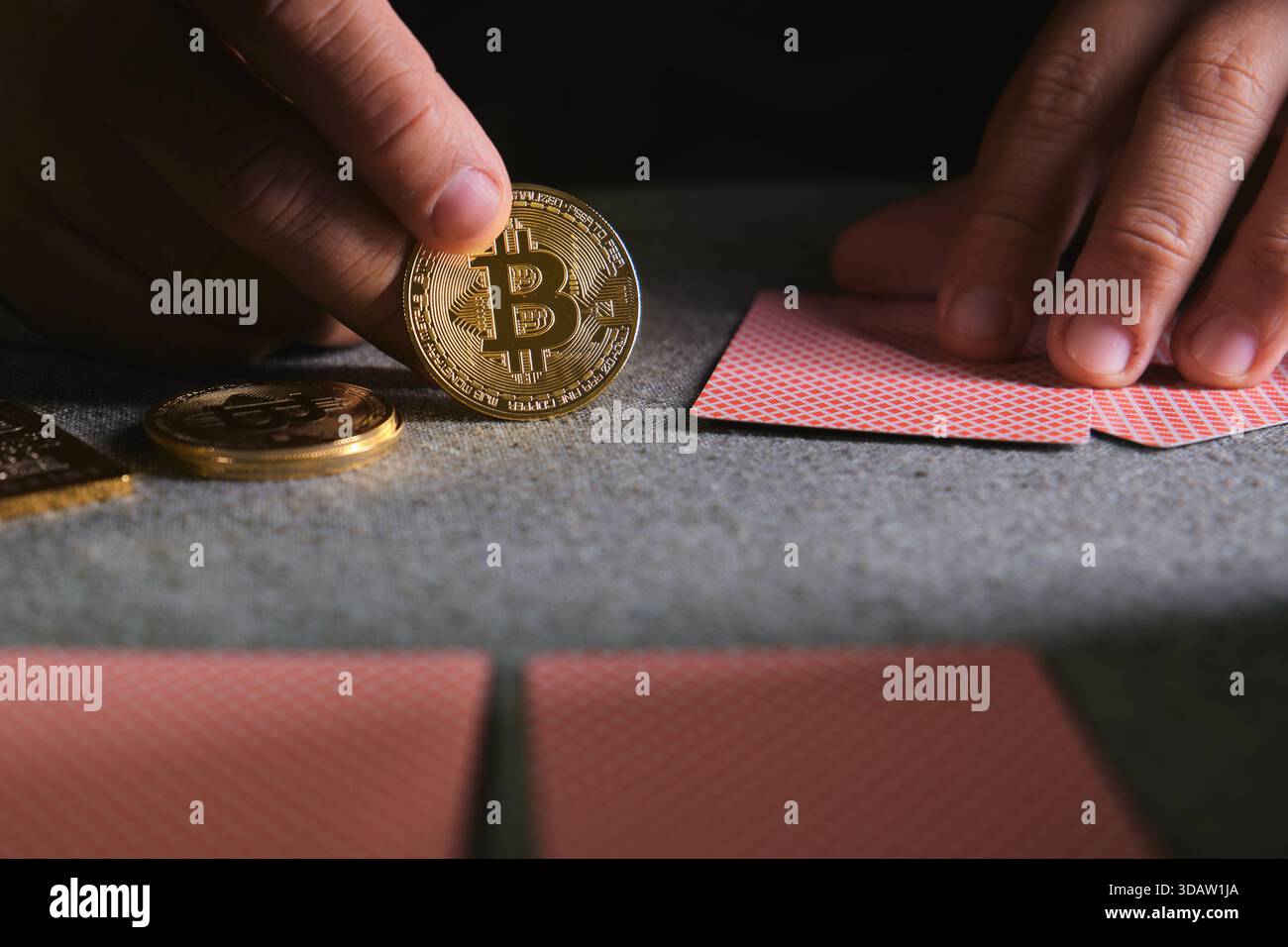 Hand holding a bitcoin coin near playing cards and other cryptocurrency  pieces on a table Stock Photo - Alamy