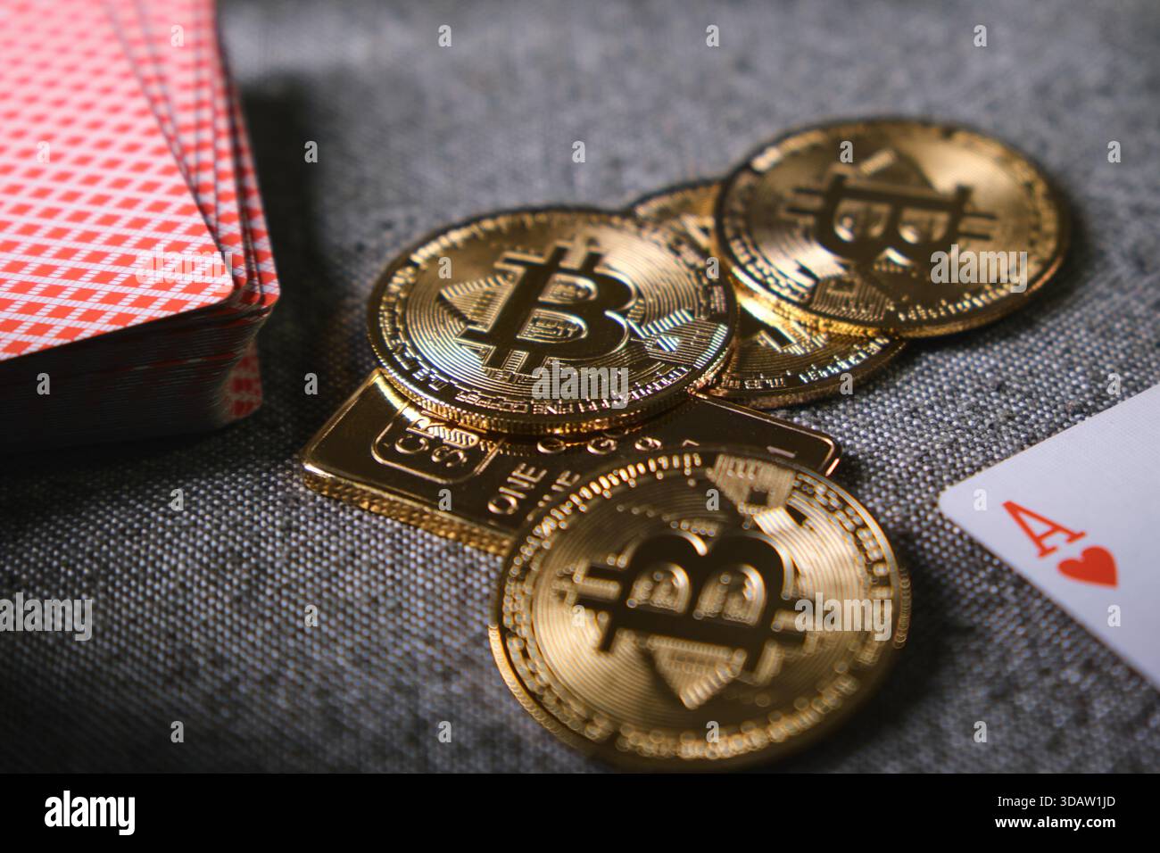 Bitcoin physical coins, gold bar, and playing cards representing  cryptocurrency gambling risks Stock Photo - Alamy