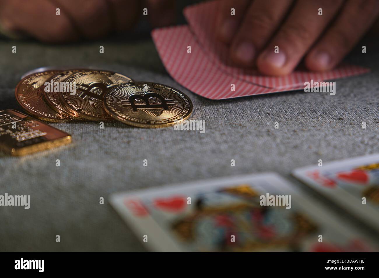 Hands holding playing cards next to crypto coins and a gold bar on a casino  game Stock Photo - Alamy
