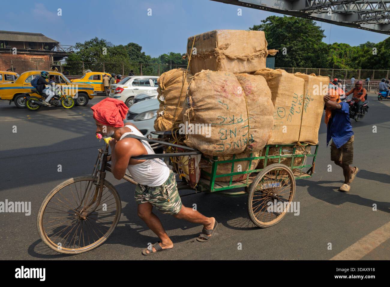 Two men transporting sacks of goods in a cycle rickshaw Stock Photo - Alamy