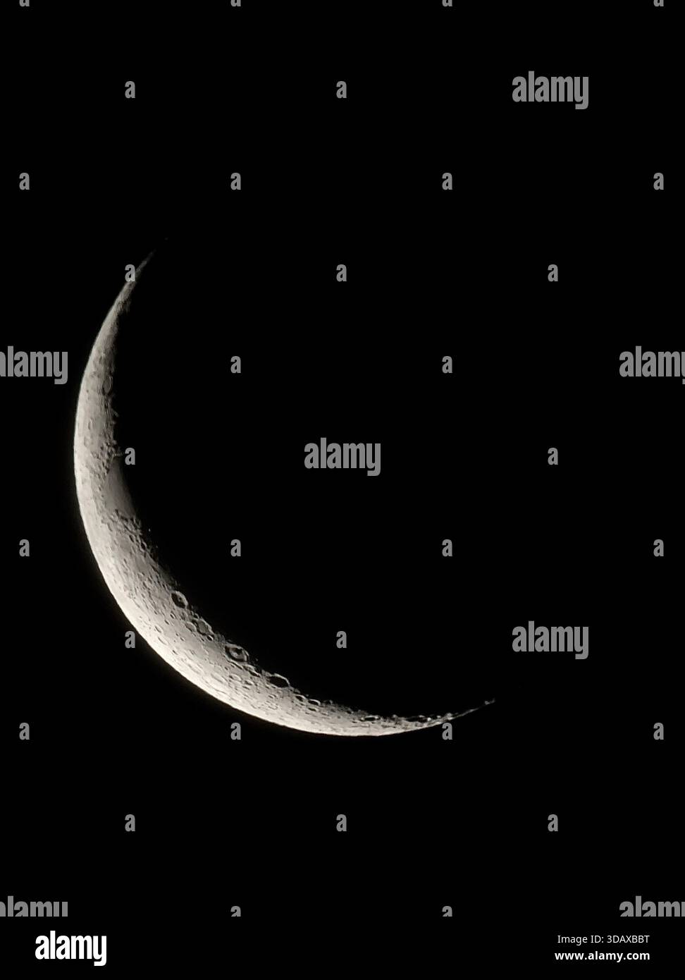 A delicate crescent moon carved in light against the deep black sky - Smartphone Captured Stock Image