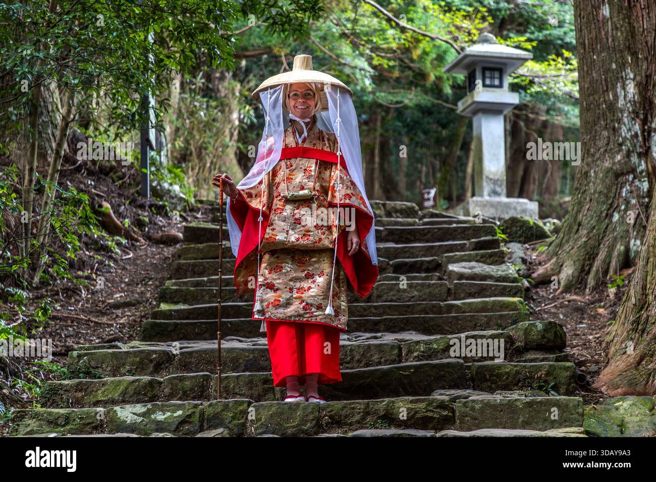 One of the most beautiful photo spots on the Kumano Kodo pilgrimage route is Daimon-zaka, with its historic stone steps near Nachi Taisha. Person dressed in traditional Japanese clothing on the rocky Kumano Kodo pilgrimage route in Nachikatsuura. Wakayama Prefecture, Japan Stock Photo