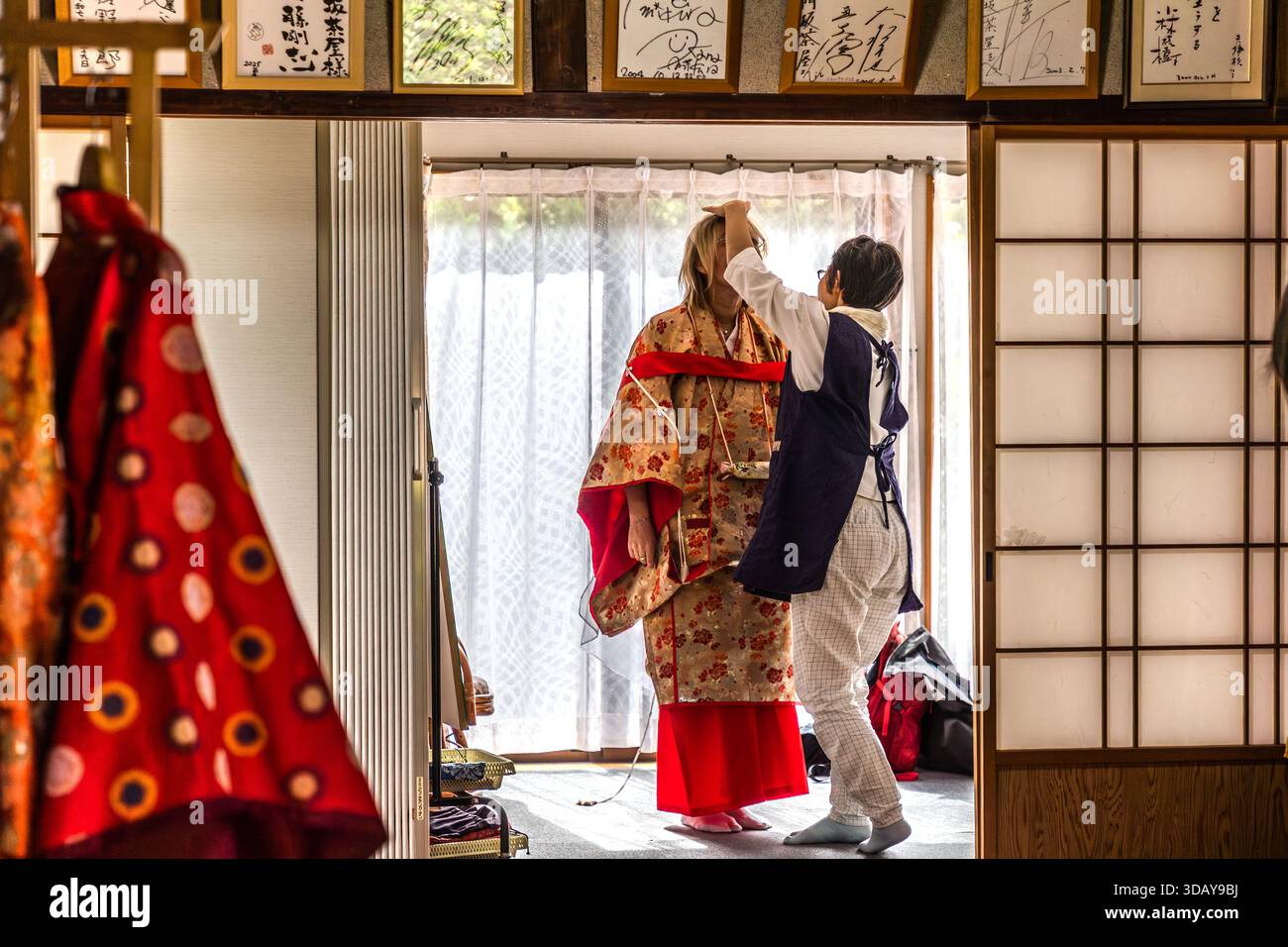 Heian Kimono Rental at Nachi-Katsuura. Women and men can dress up in Heian period clothing and walk the historic pilgrimage route up to Nachi Taisha Shrine in kimonos. Trying on a traditional kimono robe in Nachikatsuura, Wakayama Prefecture, Japan Stock Photo